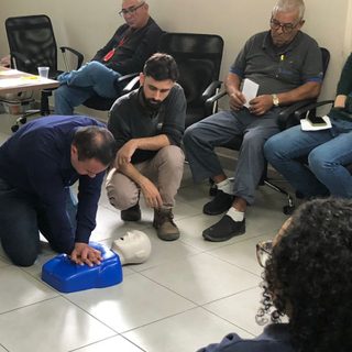 Treinamento de primeiros socorros com manequim de RCP em sala de empresa
