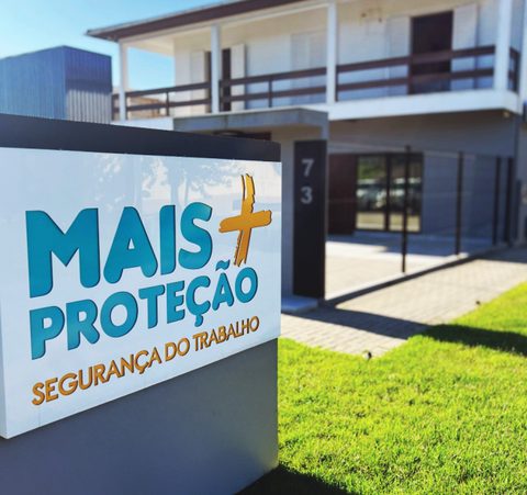 Placa com o logo da Mais Proteção no jardim da sede